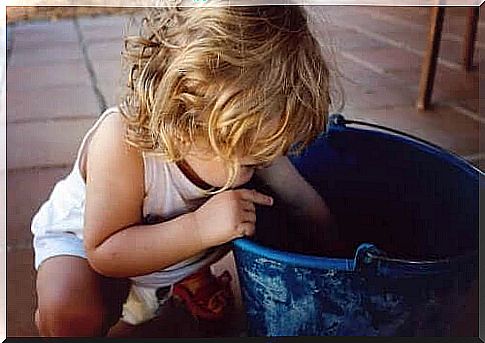 Left-handed child with a blue bucket