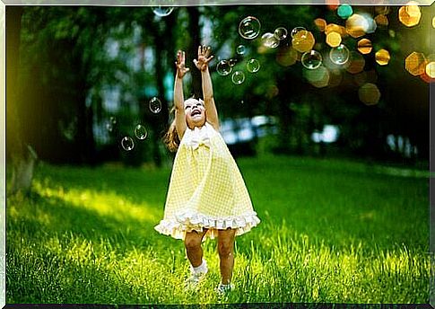 Happy little girl with soap bubbles