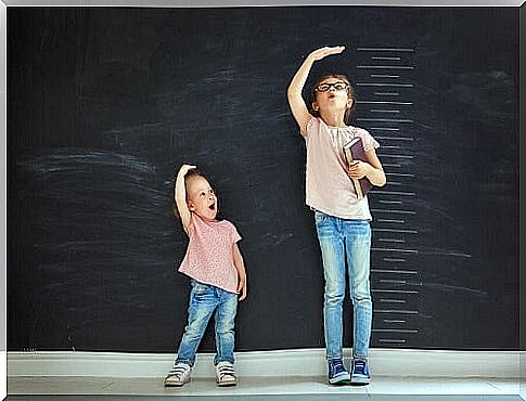 two little girls measure the height next to each other