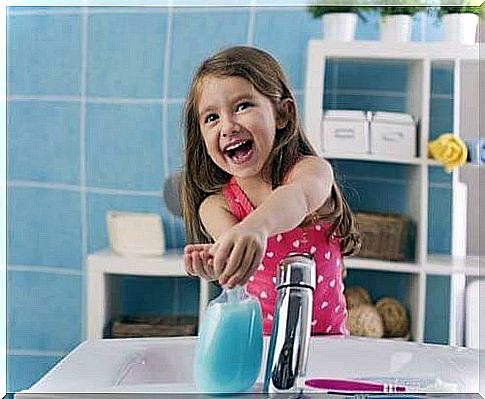 Little girl washes her hands