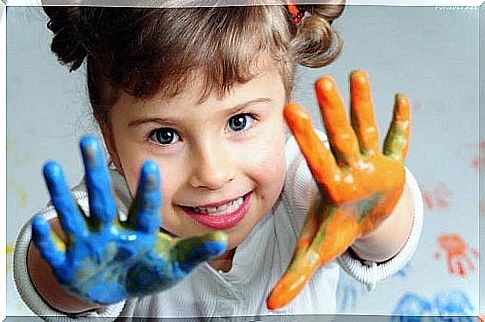 bambina con vernice sulle mani 