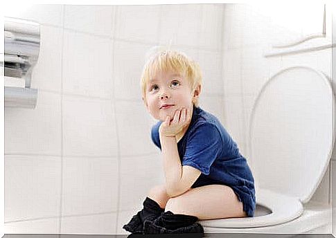 Child sitting on the toilet peeing