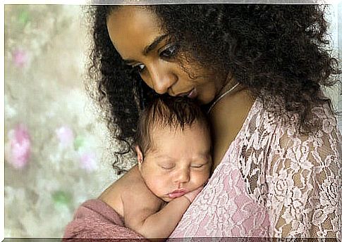 Mom holds her newborn son in her arms