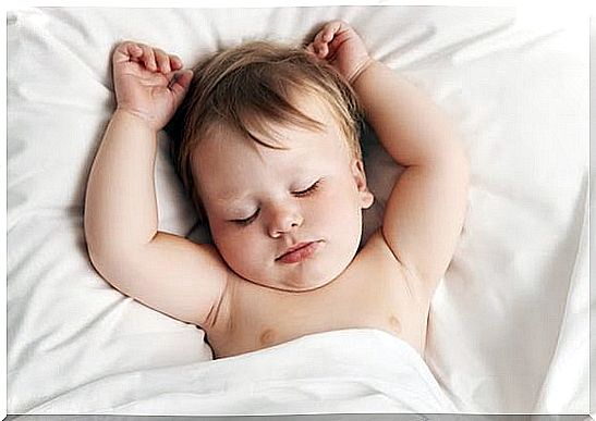 baby sleeps with raised arms