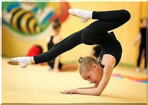 Little girl practices rhythmic gymnastics