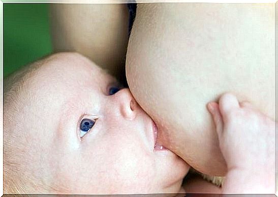First days at home with a newborn: a mother is breastfeeding.