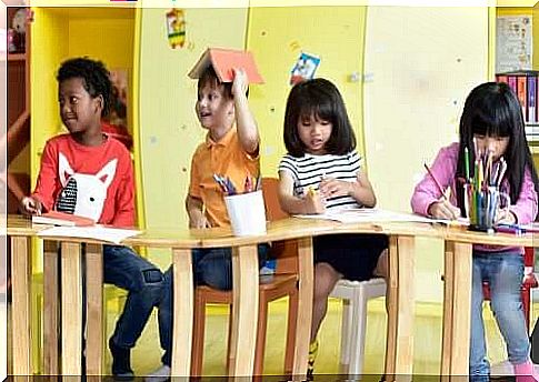 children sitting on the desks draw with colors