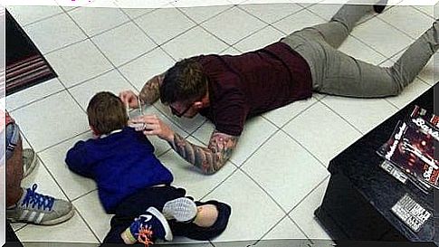 Father plays on the floor with his son