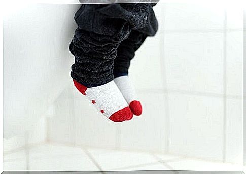 Baby's feet hang from toilet