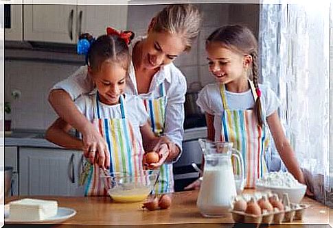 Mom preparing a cake with her daughters