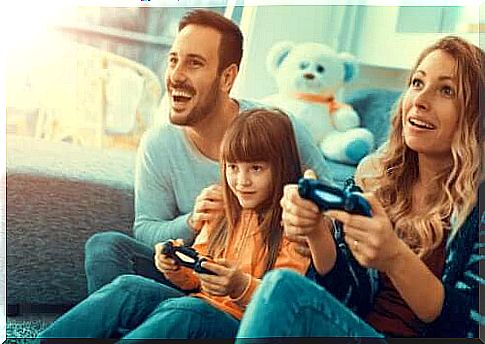 Parents playing play station with their daughter